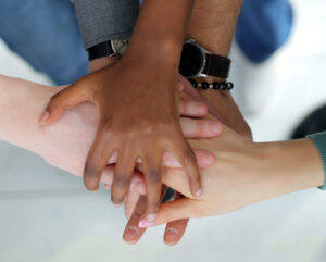 Group of people placing hands on top of each other