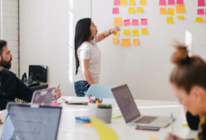 woman moving sticky notes on a board during a workshop